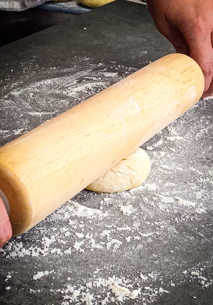 Pressing the rolling pin down across the center of the testal