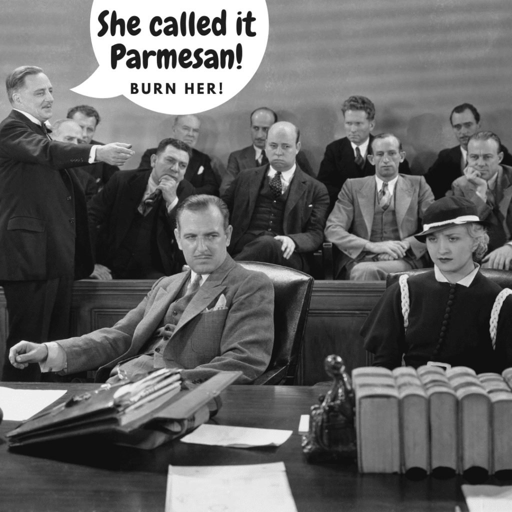 an old black and white photo of a court room with a lawyer man pointing at the defendant, a woman, with the words "She called it parmesan! burn her!" in a white speech bubble