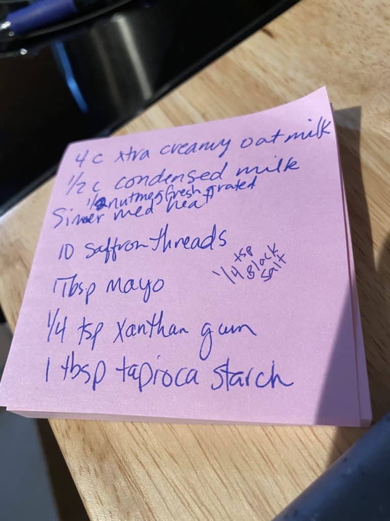A purple post it note with blue ink, with ingredients and amounts scribbled on it.