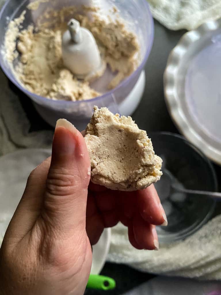 A piece of pie crust dough between my fingers. I've left an impression with my thumb, and the dough didn't stick to me.
