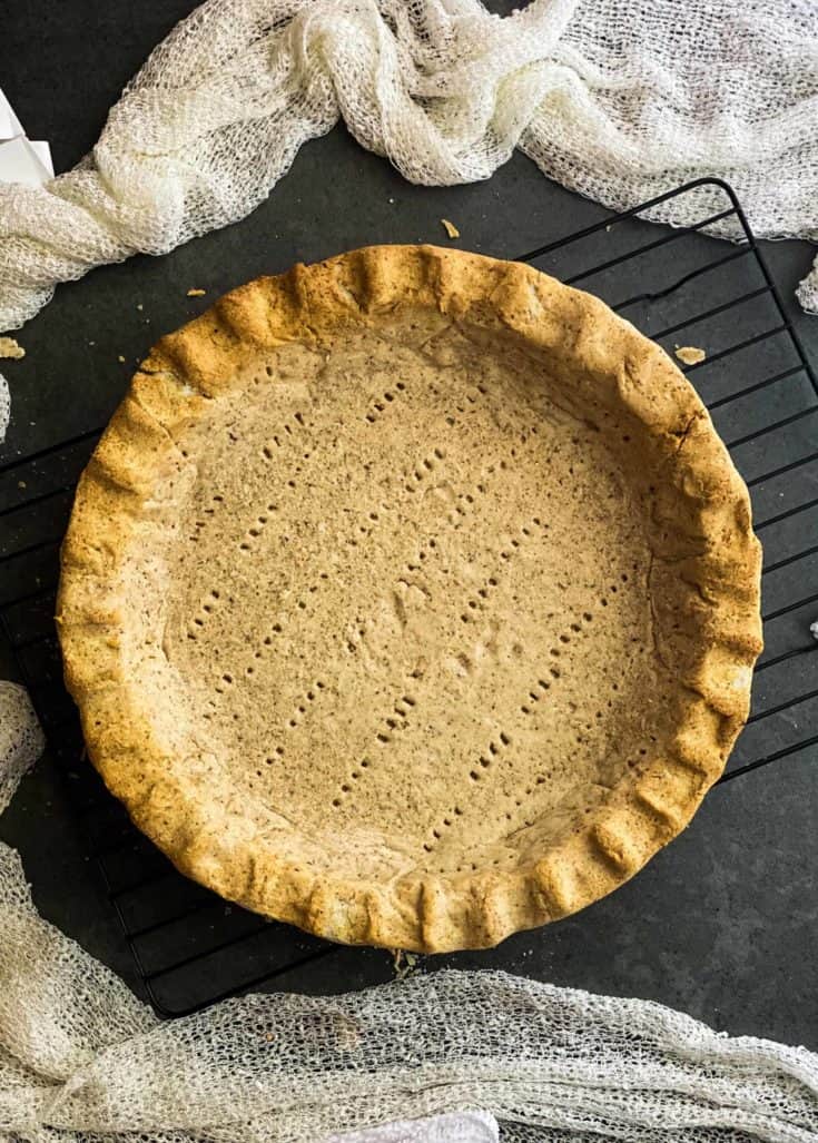 The finished golden pie crust sitting on a cooling rack.