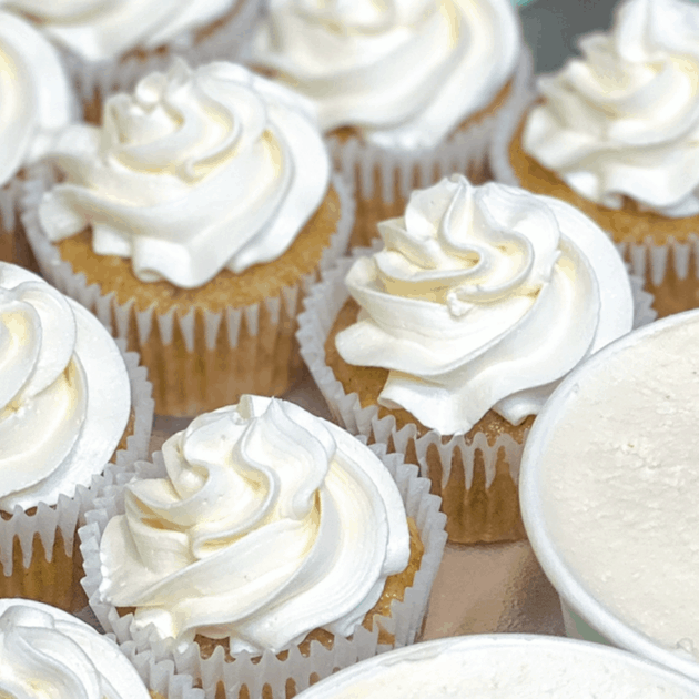 rows and rows of cupcakes with vanilla buttercream swirls